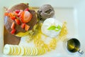Chocolate ice-cream with strawberry, whip cream served with banana, chocolate filled crepe and natural honey