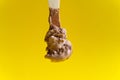 Chocolate ice cream on wooden spoon on yellow background Royalty Free Stock Photo