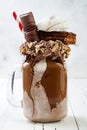 Chocolate indulgent exreme milkshake with brownie cake, marshmallow and sweets. Crazy freakshake food trend