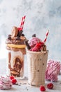 Chocolate indulgent frosting exreme milkshake with donut and sweets. Crazy freakshake food trend. Copy space