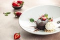 chocolate lava cake with fresh strawberries, ice-cream ball and mint, Food recipe background. Close up Royalty Free Stock Photo