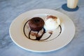 Chocolate lava cake with vanilla ice cream served on white plate, dress with chocolate syrup and brown sugar topingDelicious desse