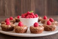 Chocolate lava cakes with fresh raspberries and mint arranged in a circle on the porcelan plate