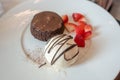 Chocolate lava fondant cake with vanilla icecream, sweet dessert on white plate with strawberry