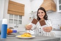 Dark-haired woman in a striped blouse showing bars of chocolate Royalty Free Stock Photo