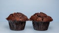 Chocolate maffin on blue background with candle and glass cognac and English money