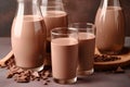 Chocolate milk in a glass and chocolate pieces on a brown background.