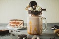 Chocolate milkshake with dripping sauce, cream, cocoa cookies and cake