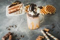 Chocolate milkshake with dripping sauce, cream, cookies and cake on dark table Royalty Free Stock Photo