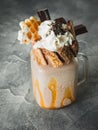 Chocolate milkshake with dripping sauce, cream, waffle and candy bar Royalty Free Stock Photo