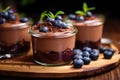 Chocolate mousse with blueberries in a glass on a wooden background, Chocolate mousse garnished with fresh blueberries served in