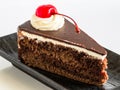 Chocolate mousse cake with whipping cream and cherry topping. Royalty Free Stock Photo