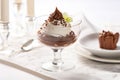 chocolate mousse in a glass dessert bowl on a white tablecloth