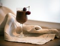 Chocolate mousse, vanilla mousse, chocolate sauce in a glass with two cherries on the wooden table. Rustic style. Chocolate mousse