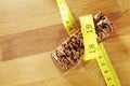 Chocolate muesli bar measuring tape on wooden background Royalty Free Stock Photo