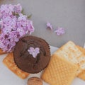 Chocolate muffin and assorted sweet pastries with empty card template and lilac flowers Royalty Free Stock Photo