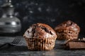 Chocolate muffin on dark background, closeup. Homemade delicious chocolate muffins on black board