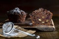 Chocolate muffin with red cherries and walnuts on a wooden table sprinkled with powdered sugar, closeup. Homemade delicious Royalty Free Stock Photo