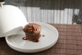 Chocolate muffin under the ceramic salver over white dish Royalty Free Stock Photo