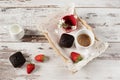 Chocolate muffins, coffee, strawberries, a vase of white flowers. Light wood rustic background Royalty Free Stock Photo