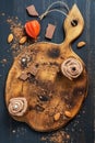 Chocolate muffins with cream and beads on an old wooden cutting board. View from above. Royalty Free Stock Photo