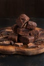 Chocolate muffins and chocolate are cut in a heap on a wooden cutting board.