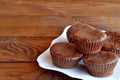 Chocolate muffins. Easy idea for gourmet dessert. Delicious chocolate cupcakes on a plate on a wooden table