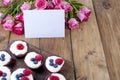 Chocolate muffins with I raspberries and blueberries, and white cheese cream, on a brown wooden board. A bouquet of fresh pink Royalty Free Stock Photo