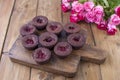 Chocolate muffins with raspberries and blueberries, and white cheese cream, on a brown wooden board. A bouquet of fresh pink roses Royalty Free Stock Photo