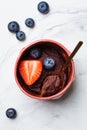 Chocolate mug cake with berries in pink cup on white marble background, top view. Fast microwave dessert recipe Royalty Free Stock Photo