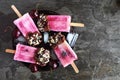 Summer chocolate and nut dipped cherry popsicles on a plate against dark slate Royalty Free Stock Photo
