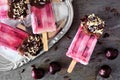 Chocolate and nut dipped cherry popsicle close up over dark slate Royalty Free Stock Photo