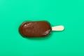 chocolate outer with milk & blueberry flavors popsicle starts melting on green background