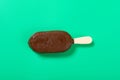 a chocolate outer with milk and blueberry flavors popsicle starts melting on green background