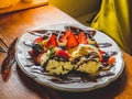 Chocolate Pancakes with banana, strawberry, blueberry, whipping cream and vanilla ice cream, icing sugar, brownies and chocolate s Royalty Free Stock Photo