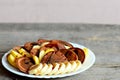 Chocolate pancakes with bananas, apples and caramel sauce on a white plate isolated on wooden background with copy space for text Royalty Free Stock Photo