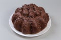 Chocolate panettone with profiteroles on dish on a gray background