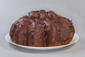 Chocolate panettone with profiteroles on dish on a gray background