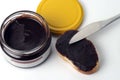 Chocolate paste in a glass jar next to a slice of white bread and a knife Royalty Free Stock Photo