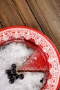 Chocolate pie with blueberry and icing sugar cut in red plate Royalty Free Stock Photo