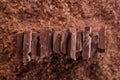 Chocolate pieces on grated chocolate background Royalty Free Stock Photo