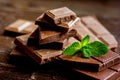 Chocolate pieces with mint on wooden table background Royalty Free Stock Photo