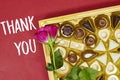 chocolate pieces from various type in box for valentine\'s day with pink rose flower and thank you text