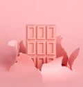 Chocolate pink tiles on pastel background against the background of hole burst paper. The concept of food is minimalism. Royalty Free Stock Photo