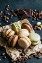 Chocolate pistachio coffee and vanilla flavored macaroons with pieces of chocolate cinnamon sticks coffee beans and pistachios Royalty Free Stock Photo