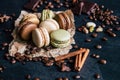 Chocolate pistachio coffee and vanilla flavored macaroons with pieces of chocolate cinnamon sticks coffee beans and pistachios Royalty Free Stock Photo