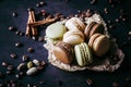 Chocolate pistachio coffee and vanilla flavored macaroons with pieces of chocolate cinnamon sticks coffee beans and pistachios Royalty Free Stock Photo