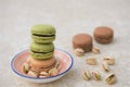 Chocolate and pistachio flavor macaroon biscuits with nuts on marble table