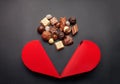 Chocolate pralines and red heart shaped box with for Valentines Royalty Free Stock Photo