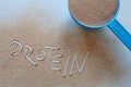 Chocolate protein powder - text protein in powder and blue measuring cup Royalty Free Stock Photo